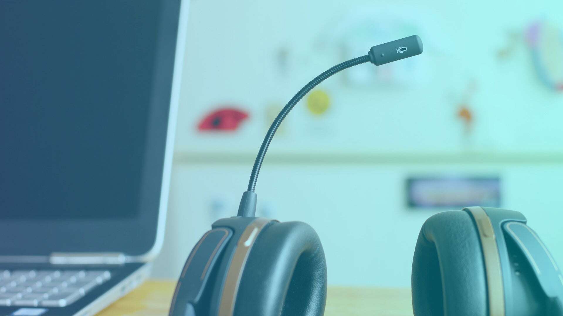 Macro photograph of a headset with a laptop in the background